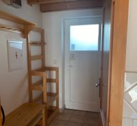 In the recreational apartment, there is a wooden hanger, a shelf, and a door with glazing.