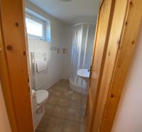 Bathroom in a Holiday Apartment with a shower, sink, and ceramic tiles.