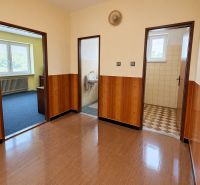 Interior of a family house with a wooden decor floor and entrances to rooms.