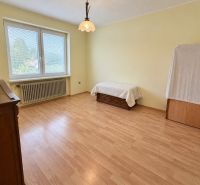 A room with a wooden decor floor in a family house with a bed and antique furniture.