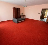 Living room with a red carpet and a cabinet in a family house.