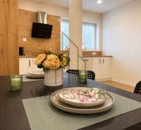 A kitchen in a 3-room apartment with a wooden decor floor and a dining table.