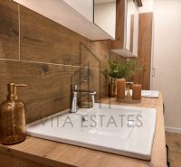 A bathroom in a 3-room apartment with wooden decor furniture and candles.
