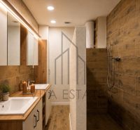 A bathroom with a wooden decor floor in a 3-room apartment.