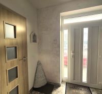 Entrance hall with decorative flooring and wooden doors in a family house.