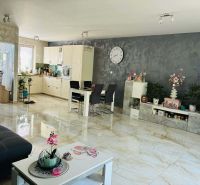 Interior of a family house with a white kitchen, dining table, and decorative elements.