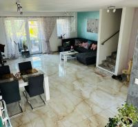 Living room with ceramic flooring, a sofa set, and a dining table in a family house.