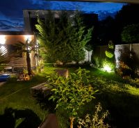 The night garden of the family house on Agátová Street in Kostolište with lighting and greenery.