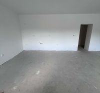 An empty room in a 3-room apartment with a concrete floor and preparation for electrical installation.