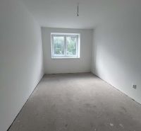 An unfurnished room in a 3-room apartment with white walls and a window.