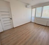 A room in a 2-room apartment with a wooden decor floor and air conditioning.