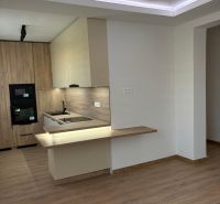 A kitchen with wooden decor and flooring in a 2-room apartment.