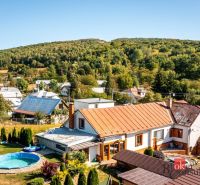 A family house in Potoky surrounded by a garden with a swimming pool and hilly nature.