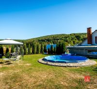 A family house in Potoky with a swimming pool and a gazebo amidst greenery.