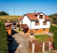A family house in Potoky with two cars and a gate on a large plot.