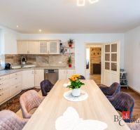 A kitchen in a family house with wooden decor and floral decoration on the table.