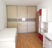 A room in a 3-room apartment with a wooden decor floor, storage space, and a bed.