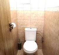 A bathroom in a 3-room apartment with ceramic tiles and subdued lighting.