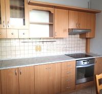 A kitchen in a 3-room apartment with a wooden decor and built-in appliances.