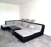 A large corner sofa in a 3-room apartment with a wooden decor floor.