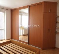 Bedroom in a 3-room apartment with a wardrobe and a bed, floor with wooden decor.