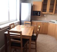 A kitchen in a 3-room apartment with a dining table and light furniture.
