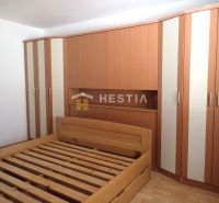 Bedroom in a 3-room apartment with a bed and a built-in wardrobe, floor with wood decor.