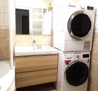 Bathroom with a washing machine and dryer, sink, and bathtub in a 3-room apartment.