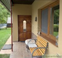 Family house in Silická Jablonica with a wooden bench on the terrace by the garden.