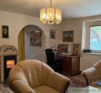 A family house with a tiled stove, flooring with a wooden decor, and vintage furniture.