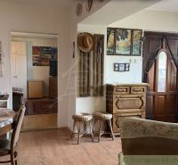 The interior of a family house with a wooden table, chairs, and decorations on the walls.