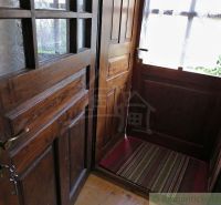 Wooden entrance area of a family house with a floor featuring a wood decor and a carpet.