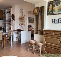 Interior of a family house with wooden decor and a kitchen with a dining table.