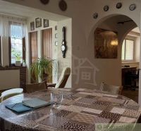Interior of a family house with a dining room, plants, and decorative elements on the wall.