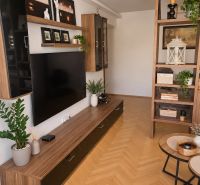 Living room in a 3-room apartment with a wooden decor floor and a wall shelf.