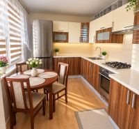 A kitchen in a 3-room apartment with furnishings and flooring in a wood decor.