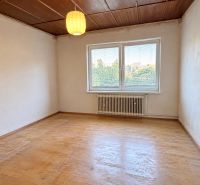 A room with a wooden floor decor, a window, a white radiator, a light fixture, a family house.