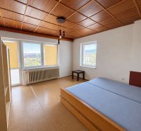 A bedroom in a family house with a wooden decor floor and simple furniture.