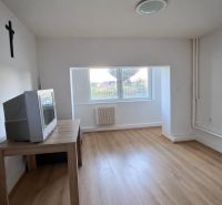 A room in a family house with a television and a floor with a wooden decor.