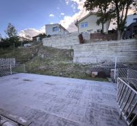 A family house in Ružomberok on K. Sidora Street, a terrace with a concrete surface and sloping terrain.