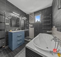 A bathroom in a villa with a bathtub, shower, and blue sink.