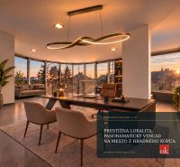 A study in a villa with large windows and a view of the city at sunset.