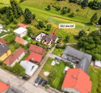 A family house in Liptovské Revúce surrounded by greenery, with neighboring properties.