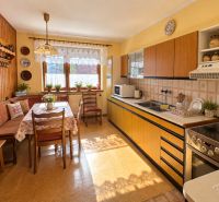 Traditional kitchen in a family house with wood decor, kitchen unit, and dining table.