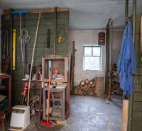 Workshop in a family house with tools, wood, and storage space.