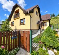 A family house in Liptovské Revúce with a well-maintained garden and a red roof.