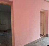 A pink wall and open doors in a family house with access to the terrace.