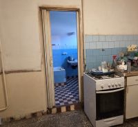 A kitchen with a gas stove and old equipment in a family house with blue tiles.