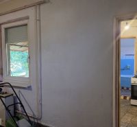 Interior of a family house with a kitchen, white walls, and a plastic window.