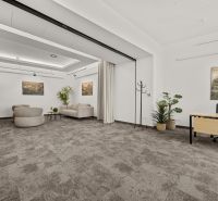 Offices with comfortable sofas, a desk, and houseplants.
